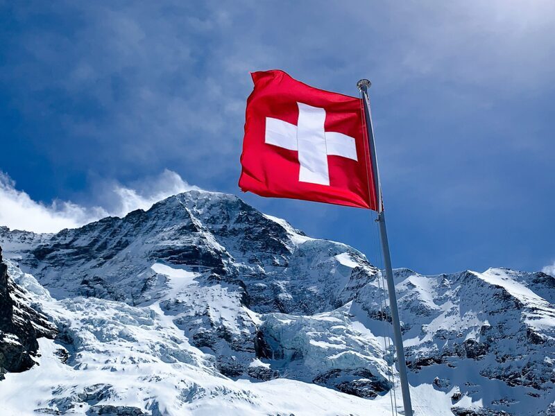 Schweizerflagge mit Bergen im Hintergrund