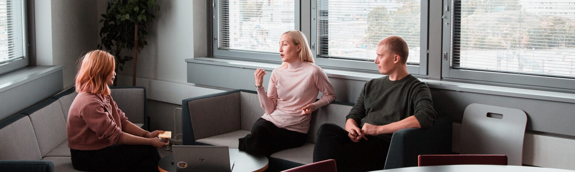 Drei Personen, die im Kreis sitzen und reden