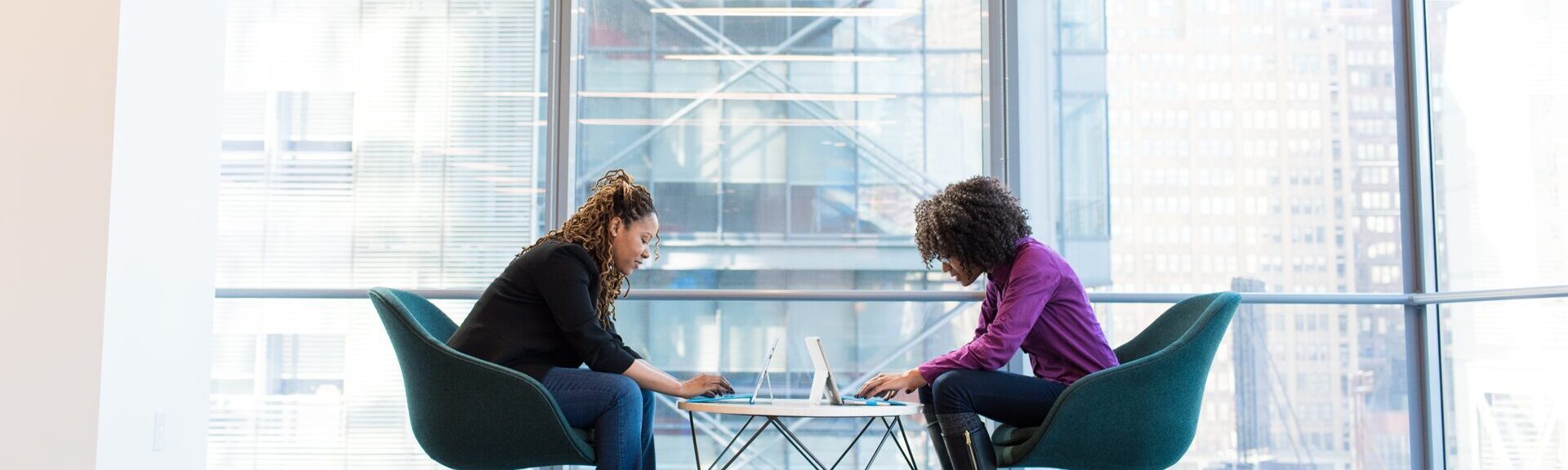 Zwei Personen die sich gegenüber sitzen und jeweils am Computer sind